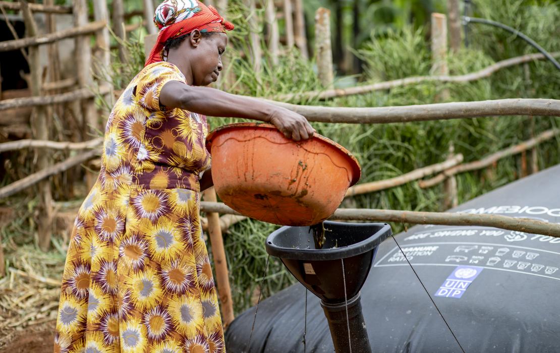 Marie Jose déverse des déchets organiques qui sont utilisés pour la cuisine, l'eau chaude et les petits générateurs électriques.