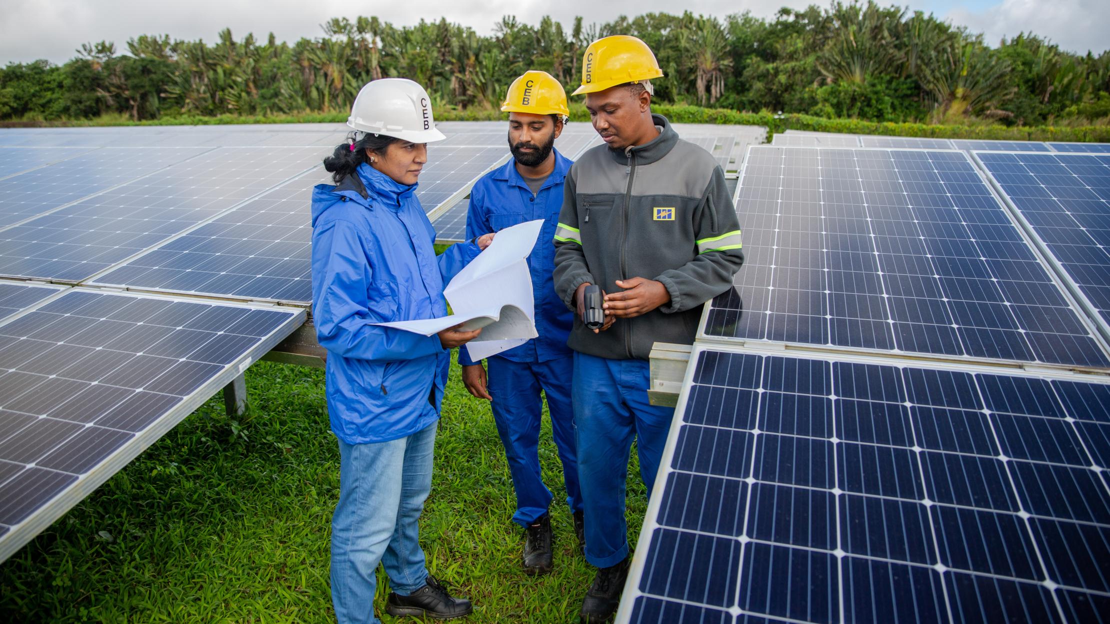 Photo : PNUD Maurice et Seychelles Femme ingénieur travaillant avec une équipe sur l'installation de panneaux solaires à l'île Maurice et aux Seychelles