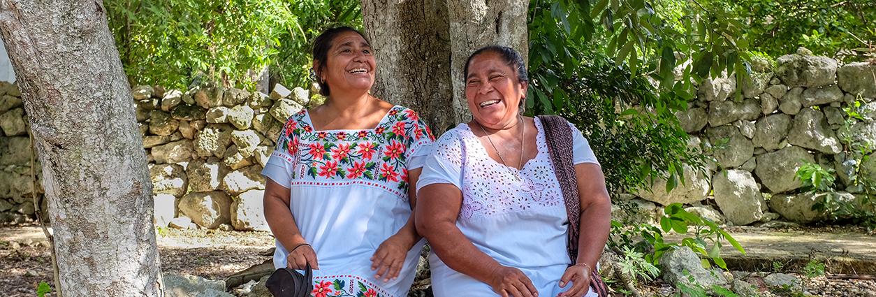 Dos mujeres descansan bajo un árbol